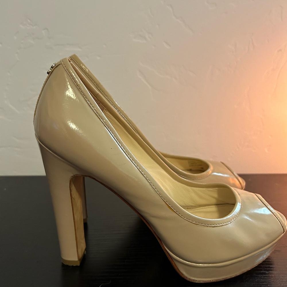 Coach brand nude, peep-toe, platform pumps.